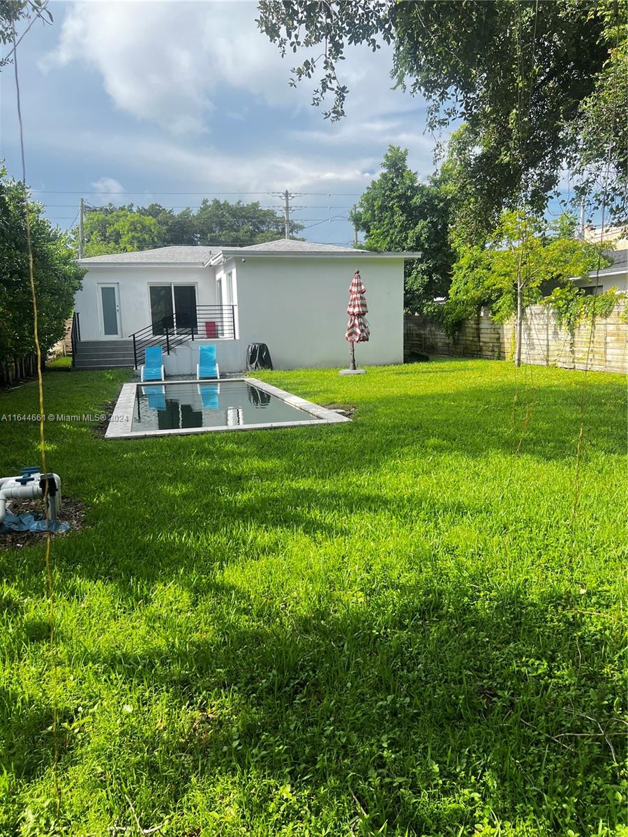 a view of a house with a backyard and a patio