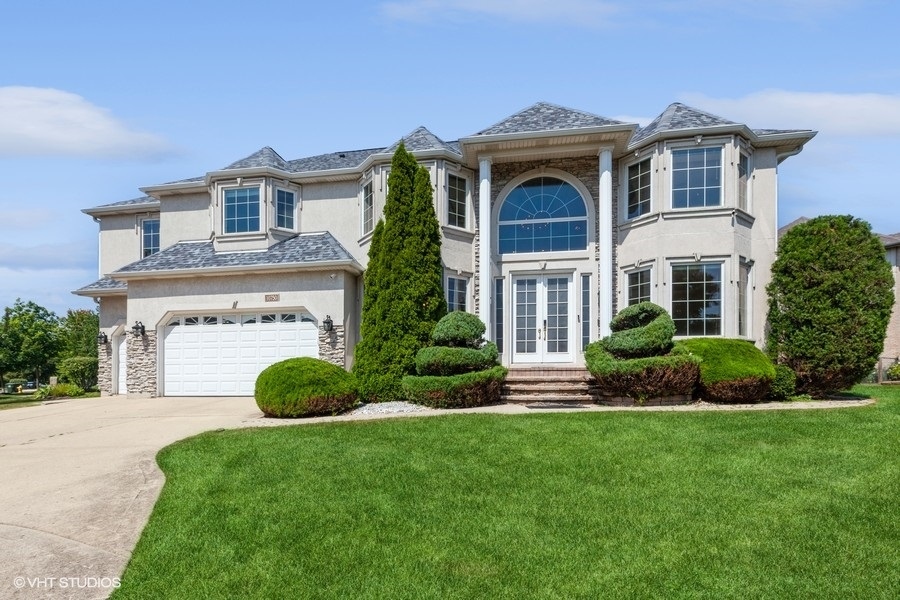 a front view of a house with a yard and garage