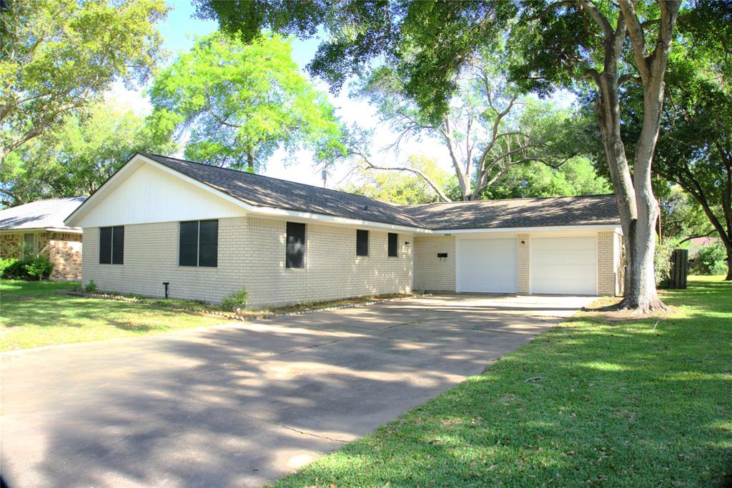 a view of a house with a yard and large tree