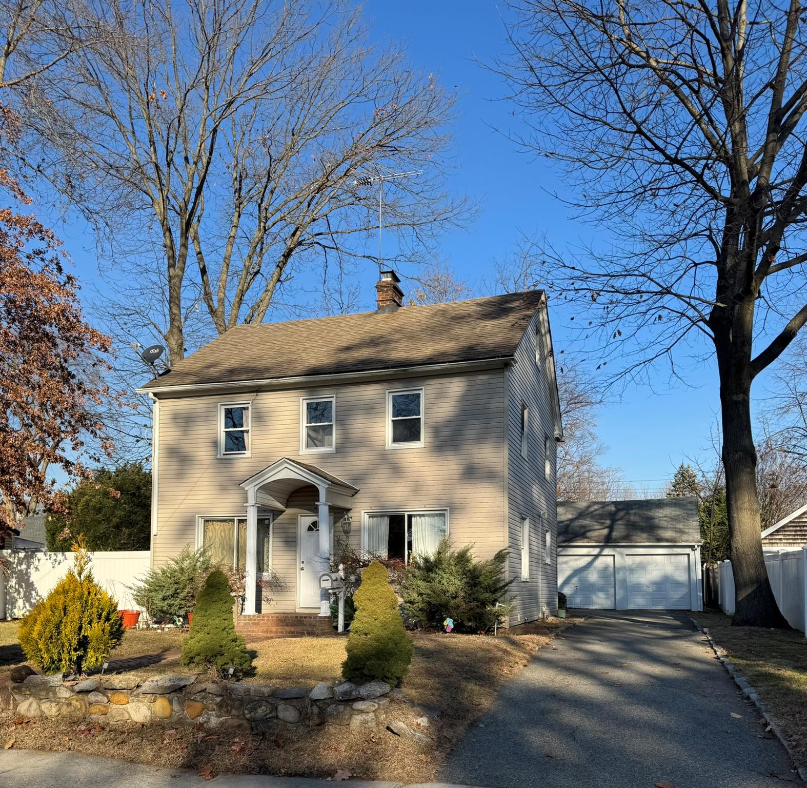 Colonial home featuring a garage and an outdoor structure