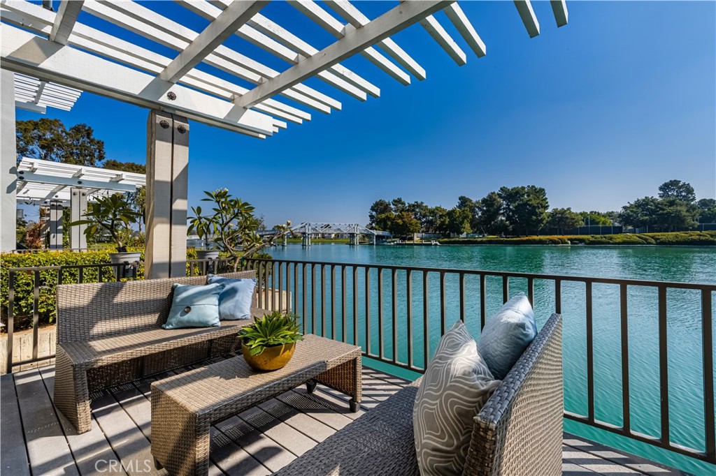 a roof deck with a couches and potted plants with wooden floor