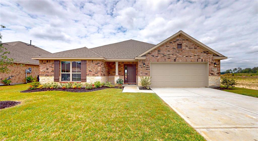 a front view of a house with a garden and yard