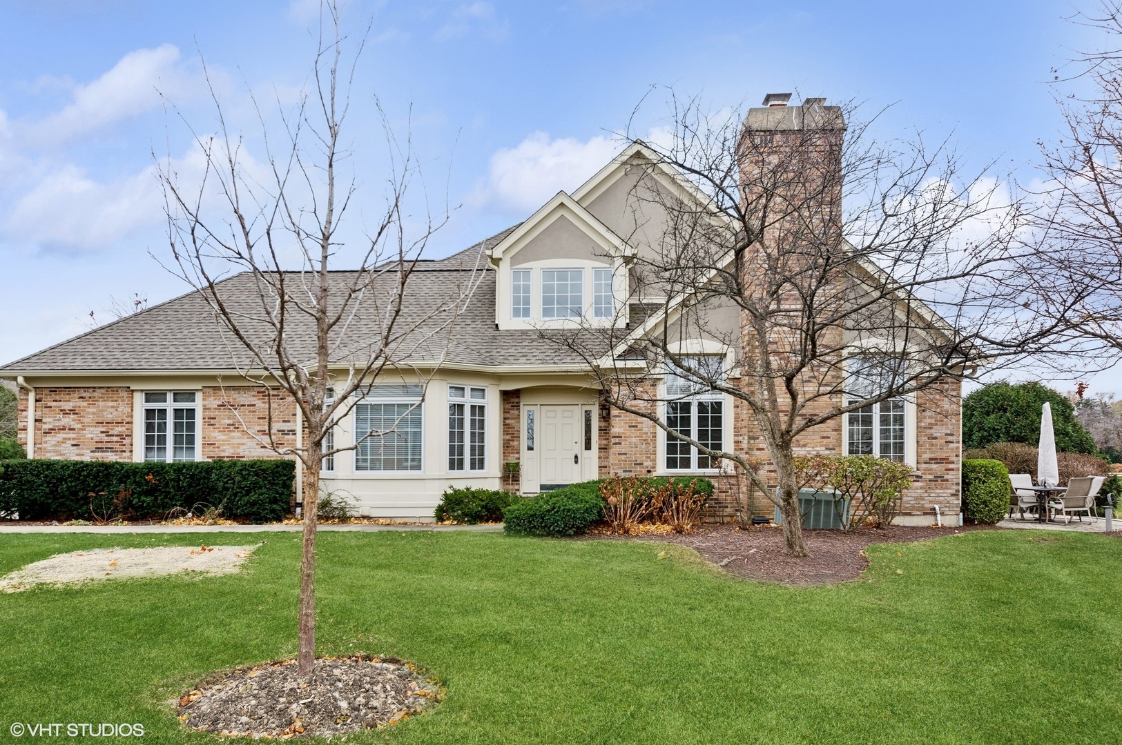 a front view of a house with a yard and trees