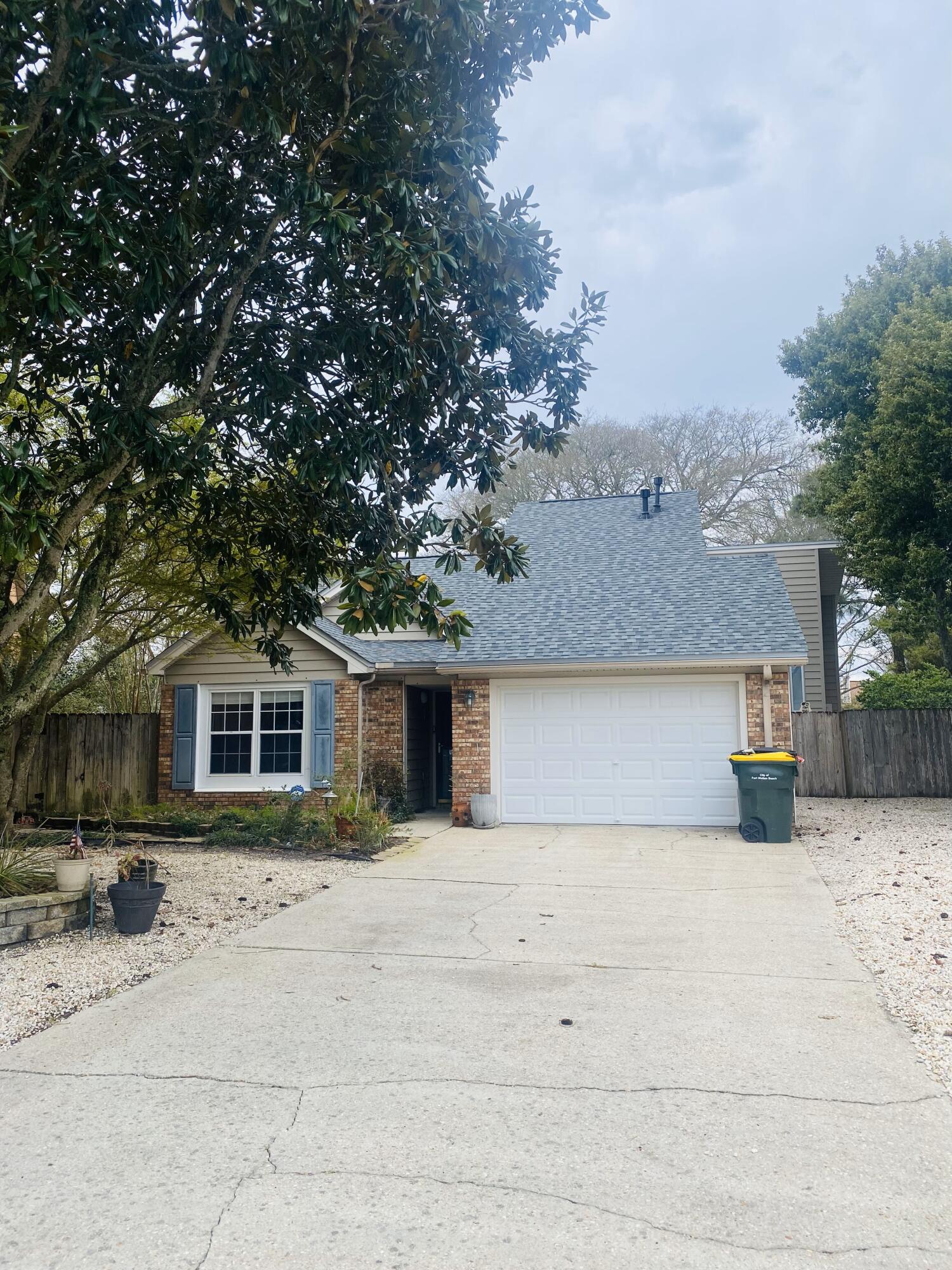 a front view of house with yard and trees in the background