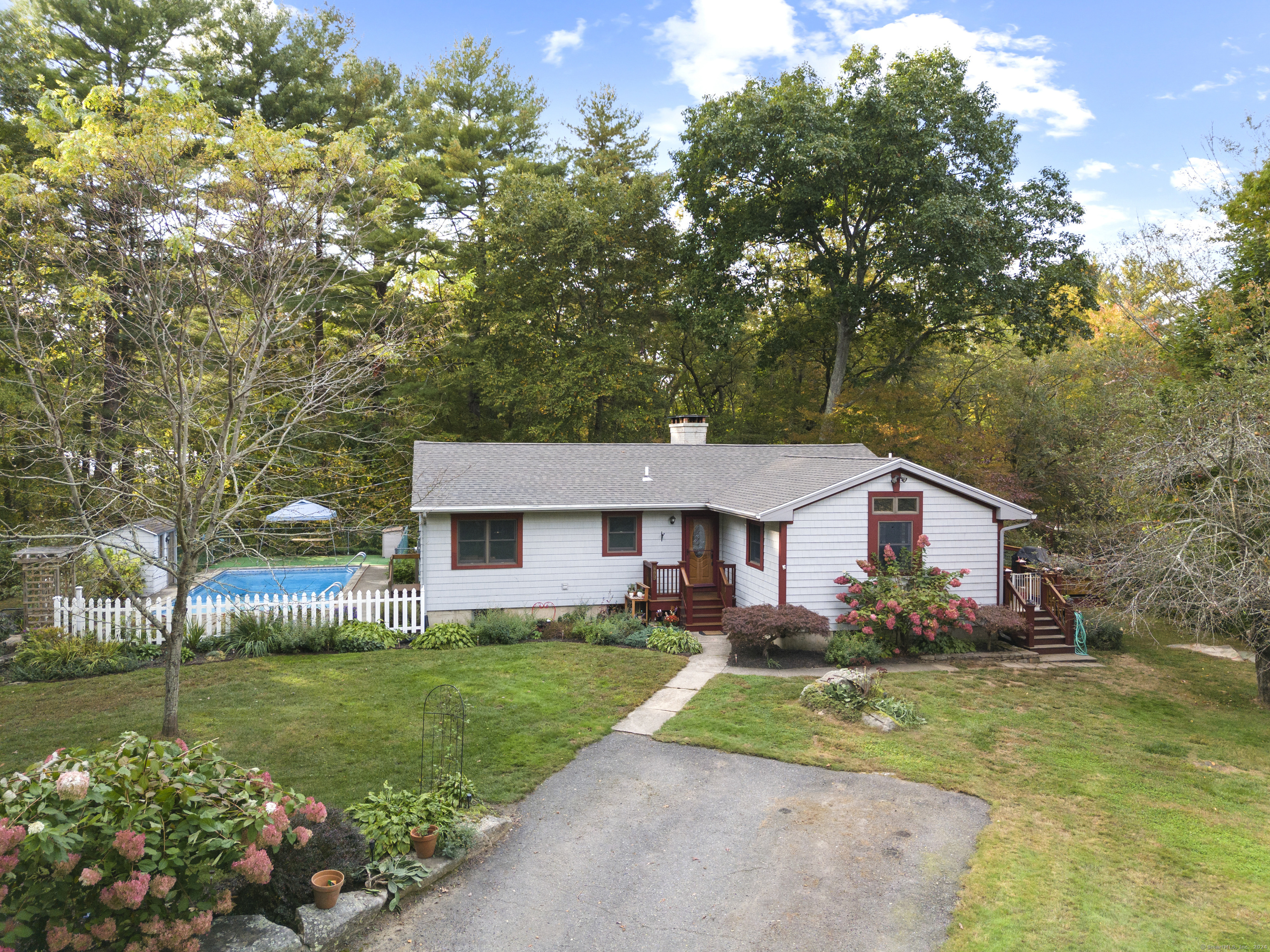 a front view of house with garden and trees