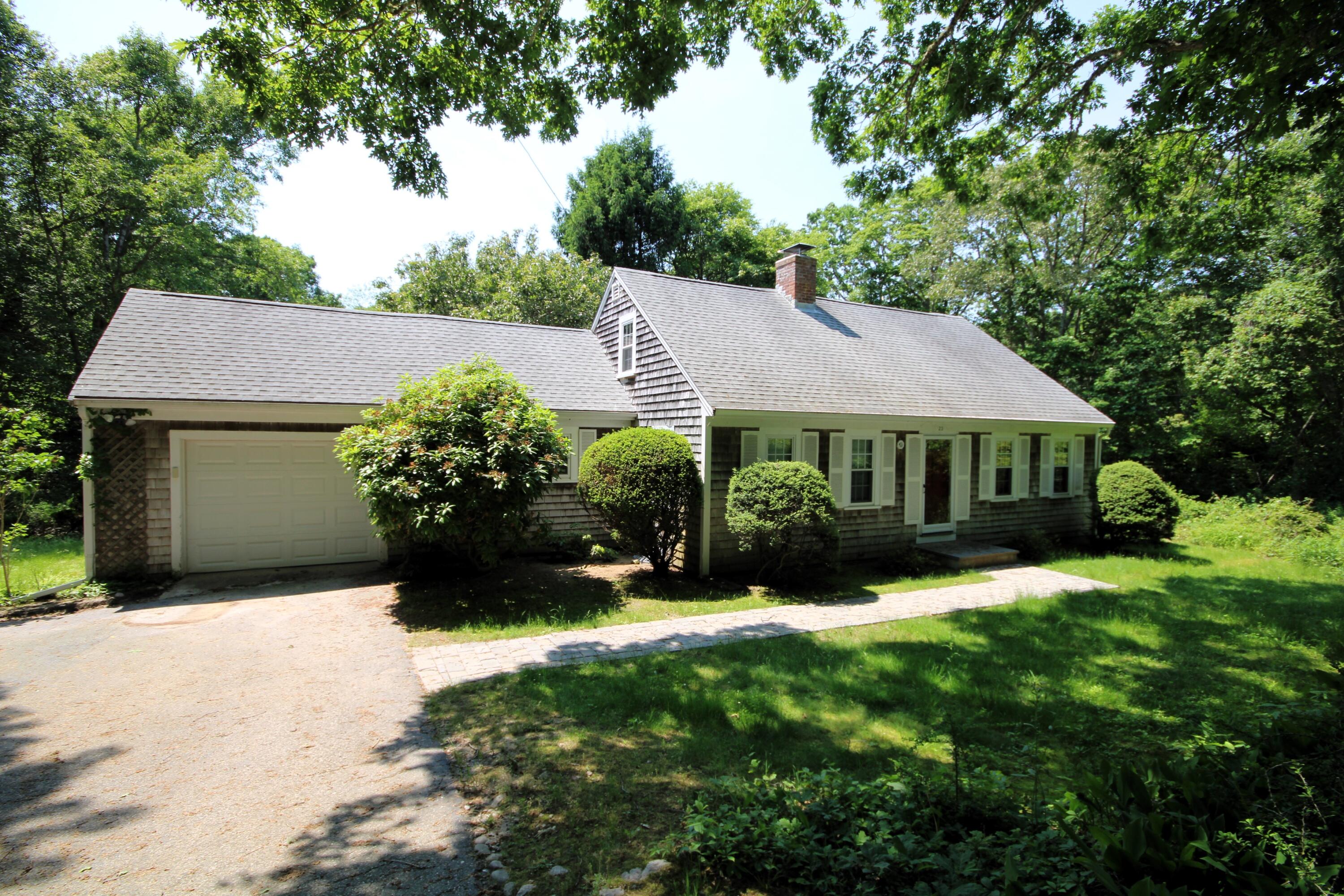 a view of house with garden and tall trees