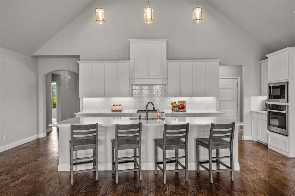 a kitchen with stainless steel appliances wooden floor dining table and chairs