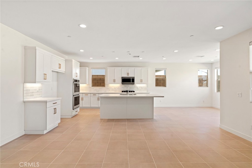 a large kitchen with a large counter top space stainless steel appliances and cabinets