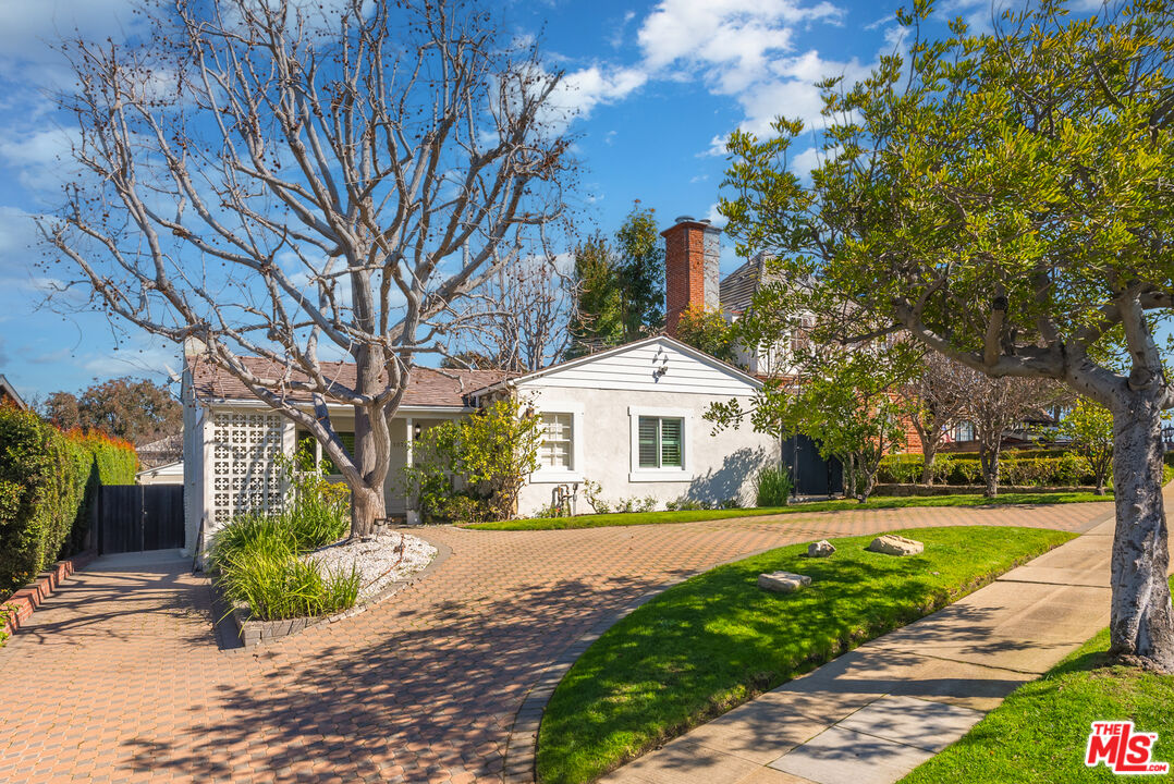 a front view of a house with a yard and potted plants