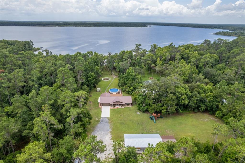 an aerial view of a house with garden space and a lake view