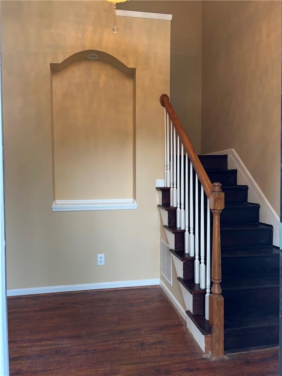 a view of a hallway with wooden floor and staircase