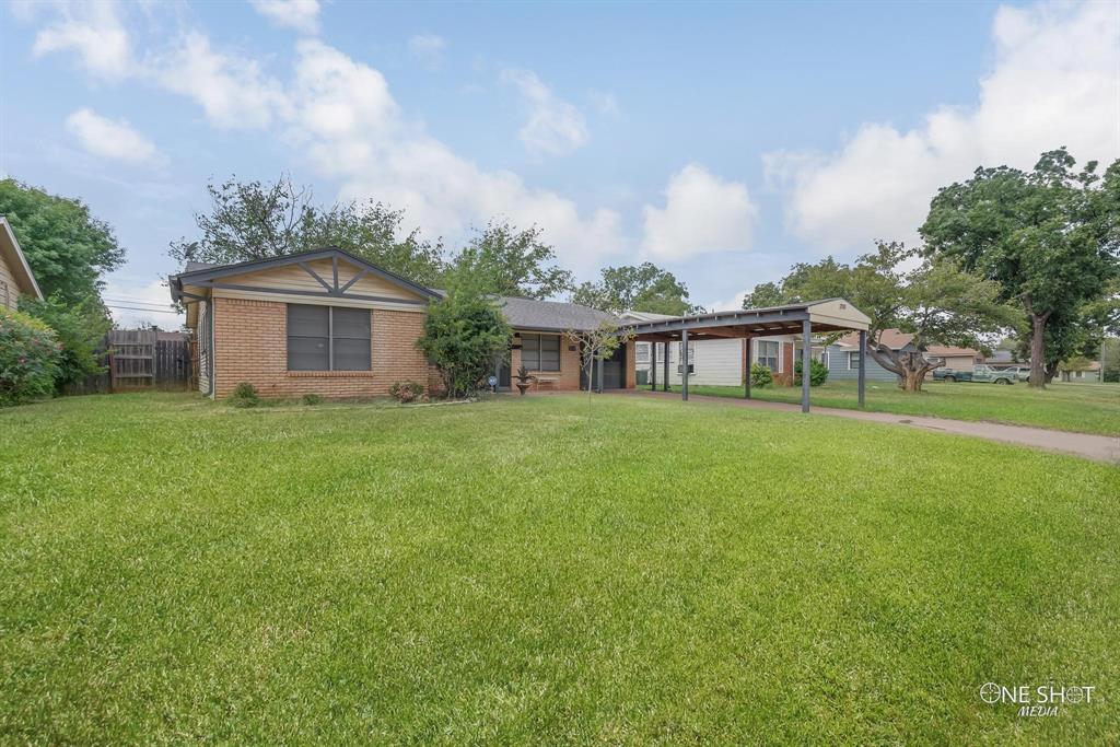 a view of a house with a yard and sitting area