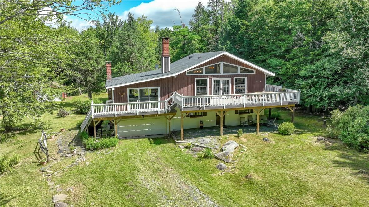 Rear view of property with a yard and a wooden deck