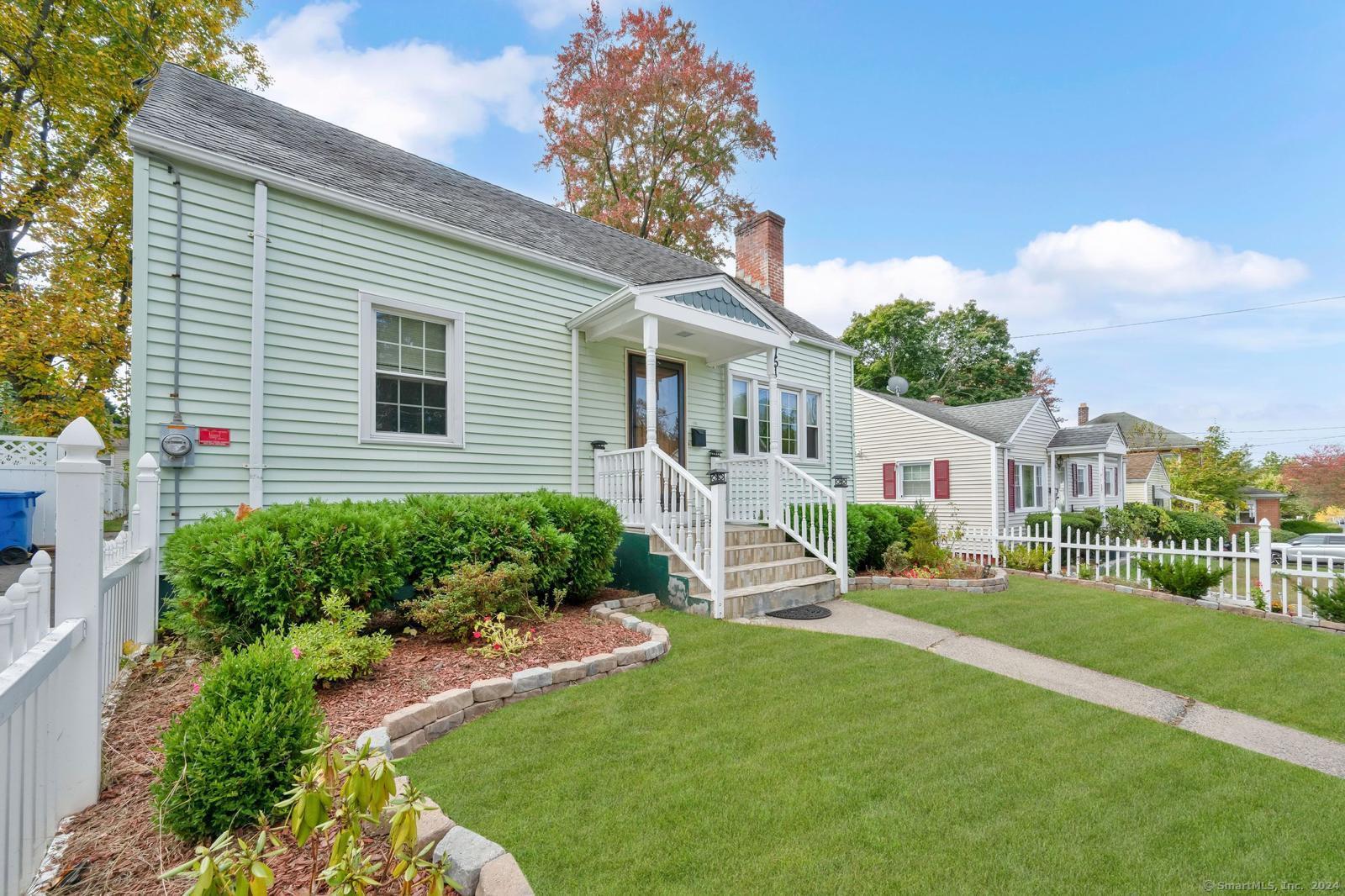 a front view of a house with a yard and green space