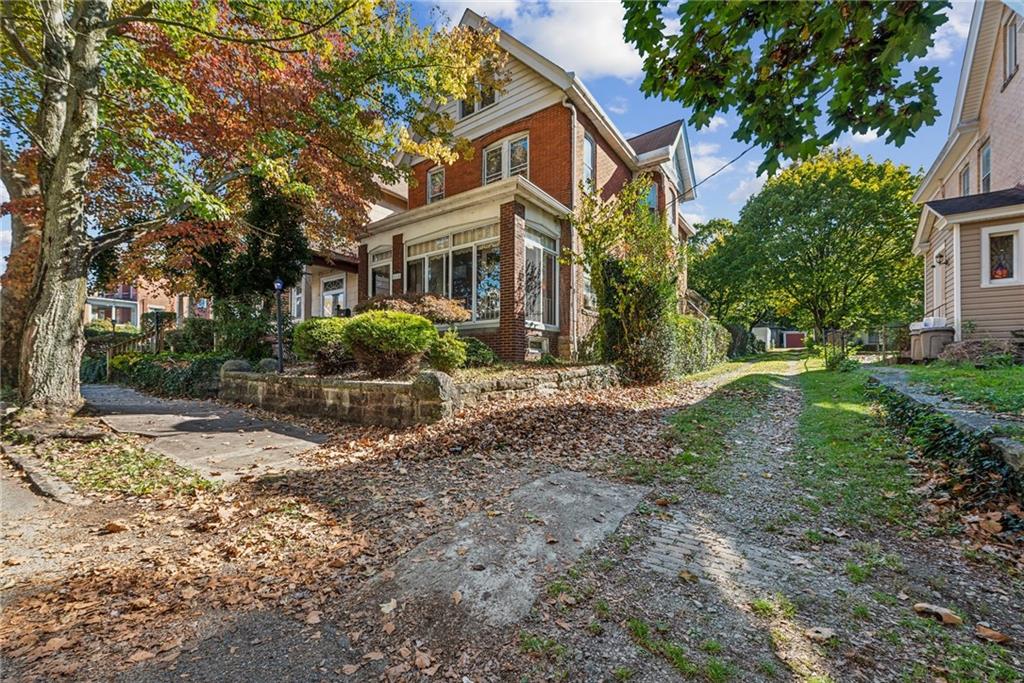 a front view of a house with a yard and shrubs