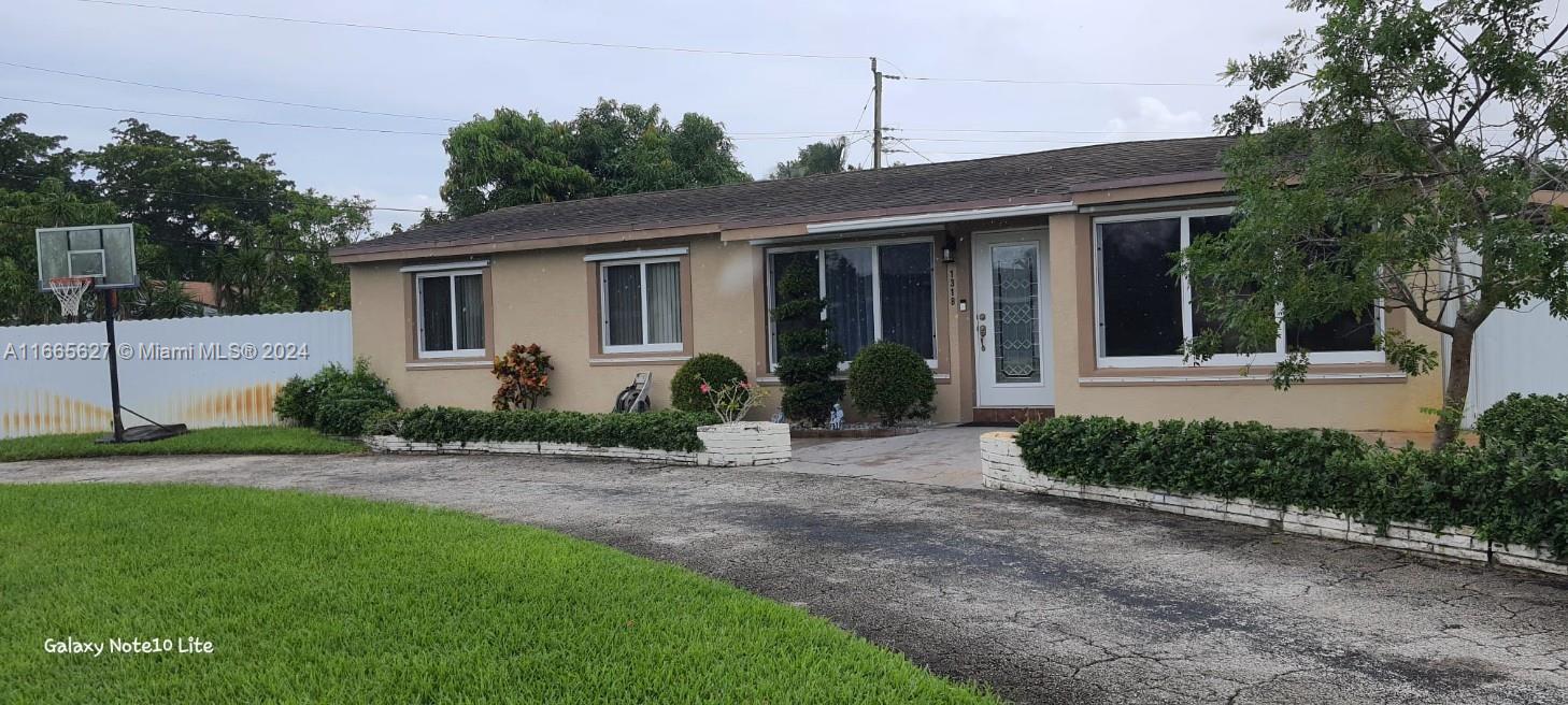 a front view of a house with a yard and potted plants