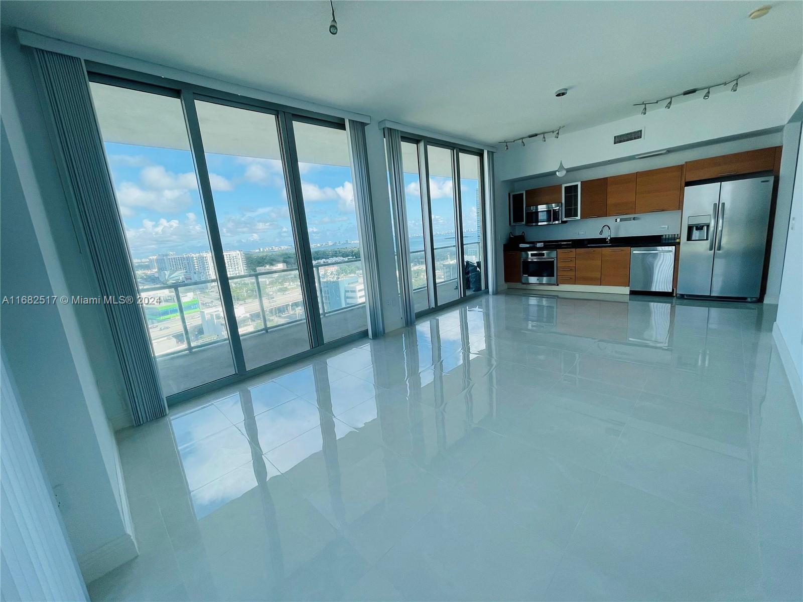 a view of an empty room with a fireplace and windows