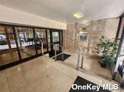 a room with lots of potted plants and glass door