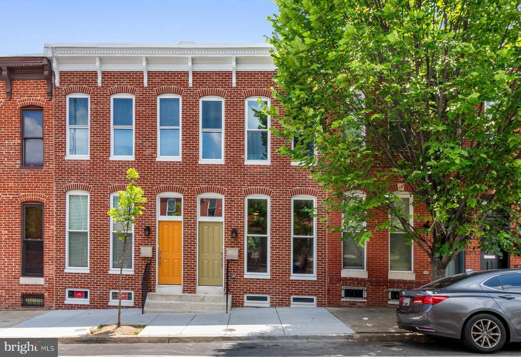 front view of a brick house with a yard