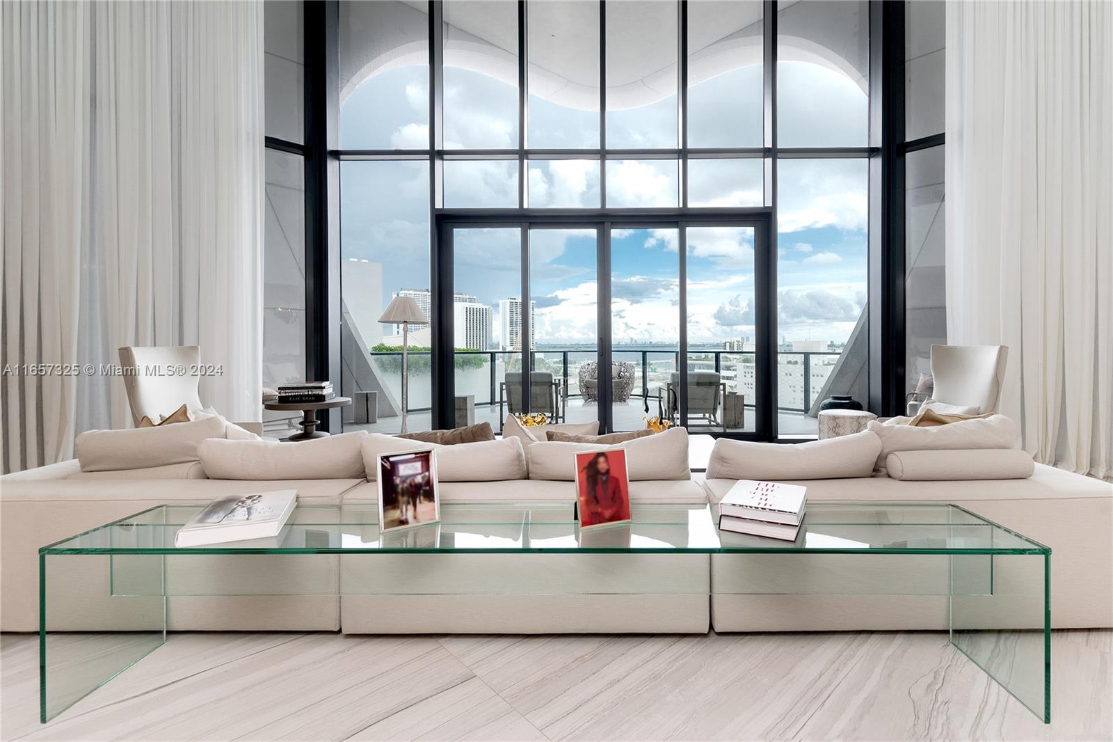 a living room with furniture and floor to ceiling windows