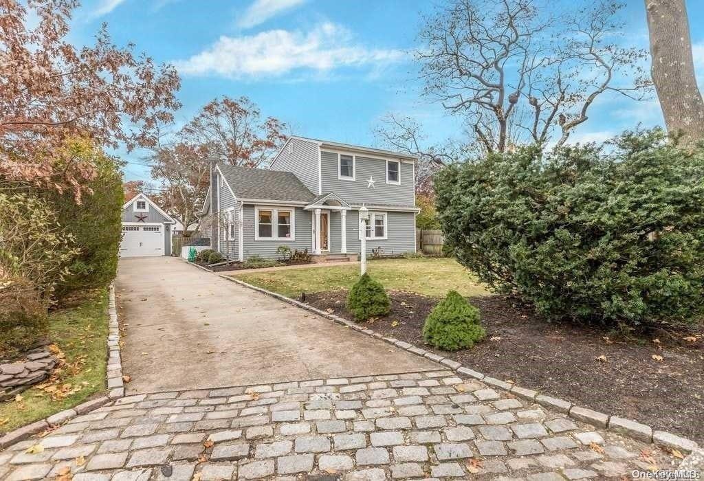 a front view of a house with a yard and trees