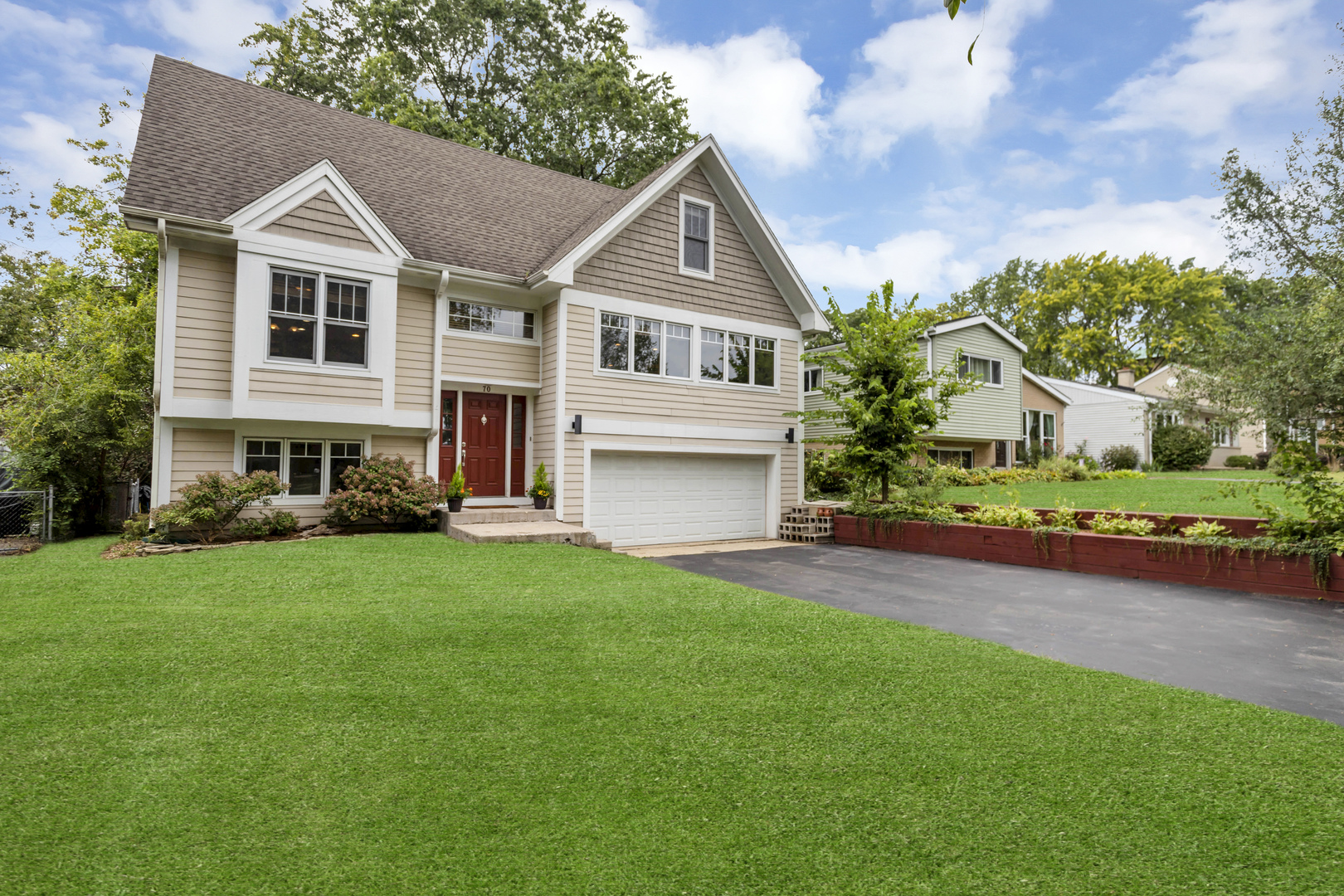 a front view of a house with a garden and yard