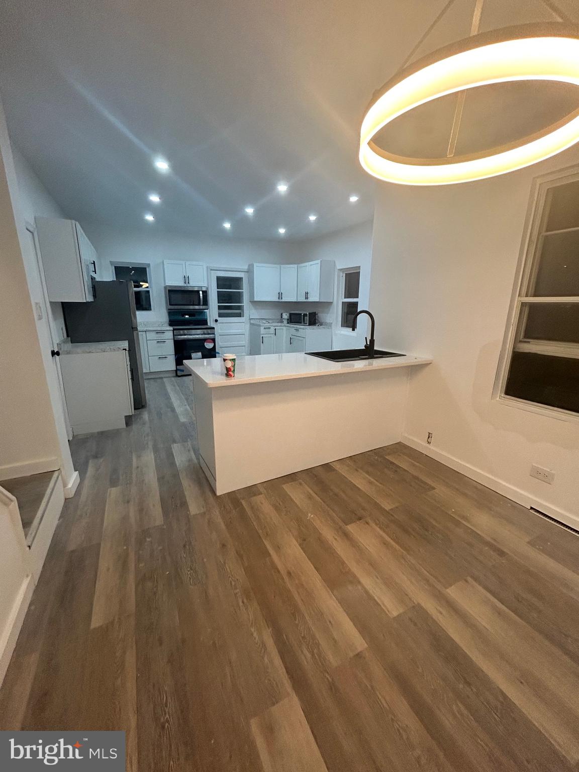 a open kitchen with white cabinets a sink and dishwasher