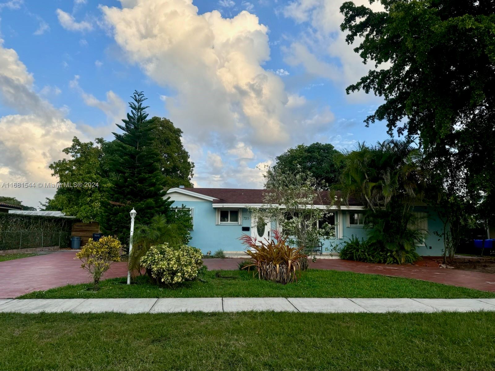 a front view of a house with a garden