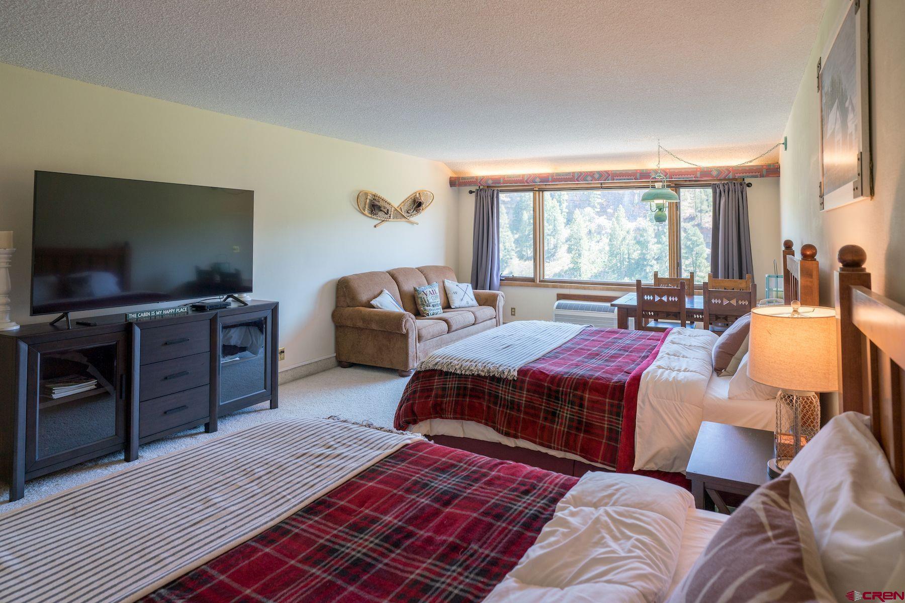 a bedroom with a bed and a flat screen tv