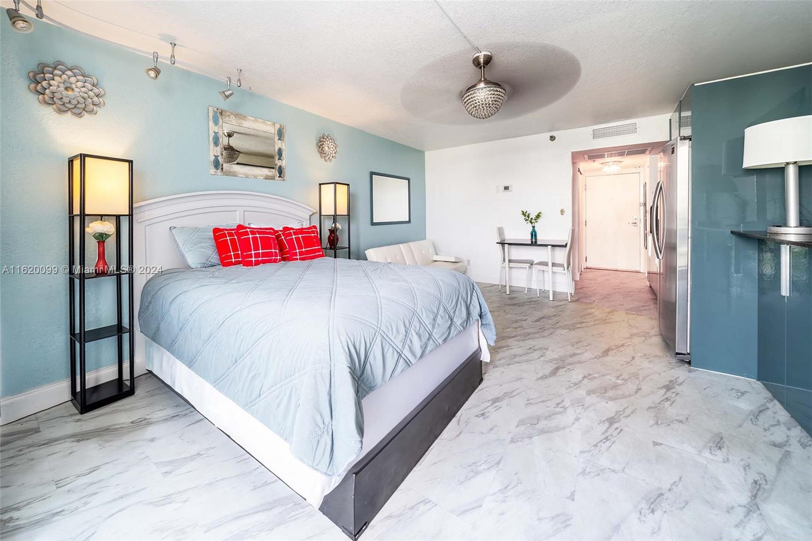 a bedroom with a large bed and a chandelier