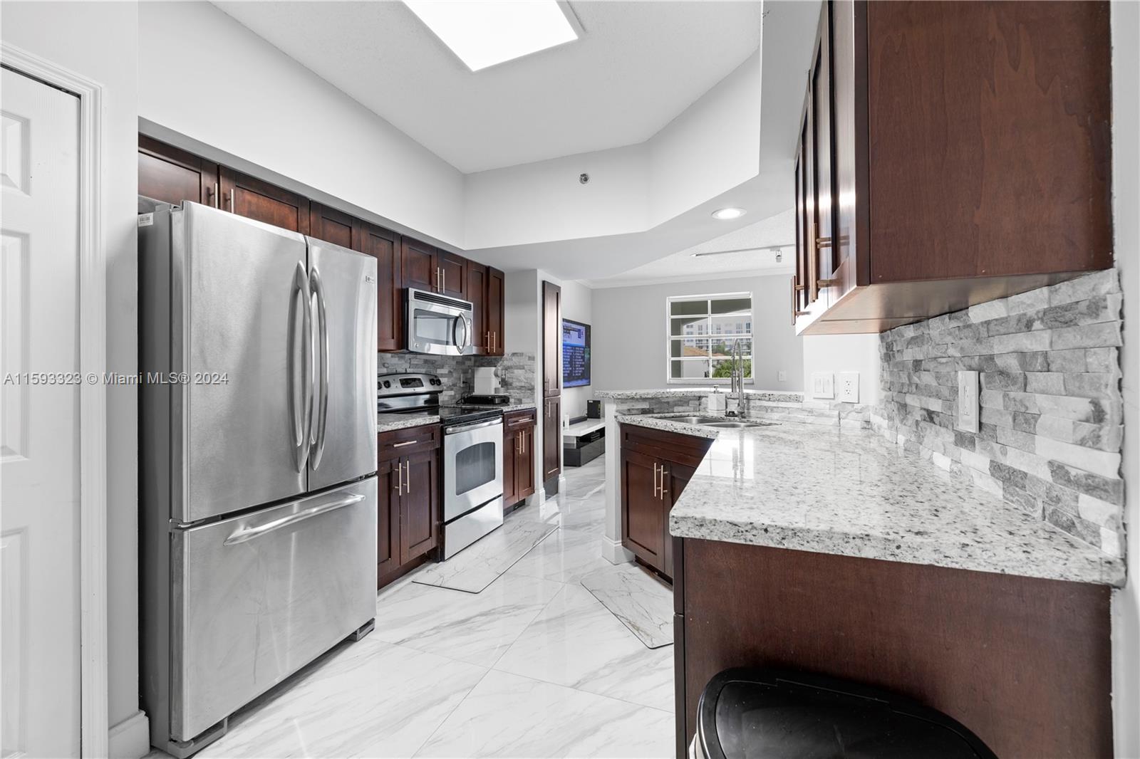 a kitchen with granite countertop a refrigerator and a sink