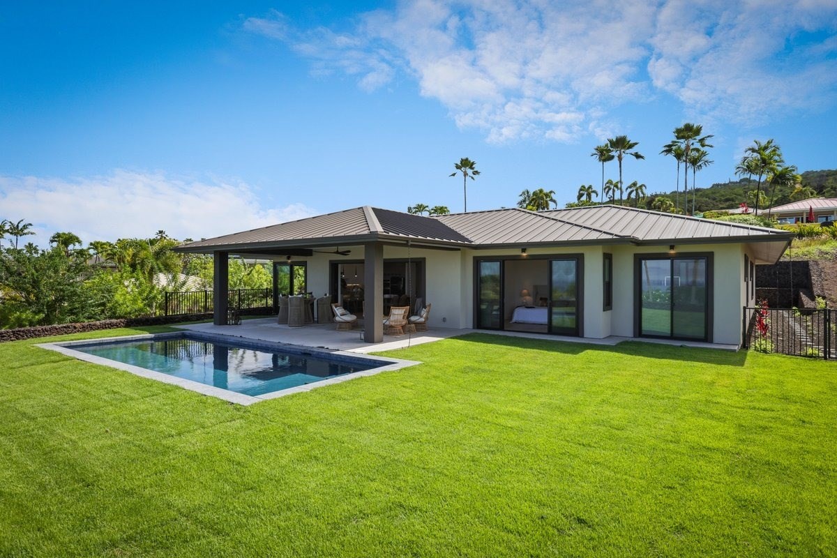 a view of a house with pool and a yard