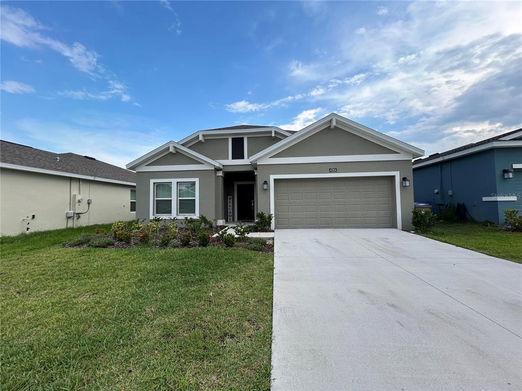 a front view of a house with a yard and garage