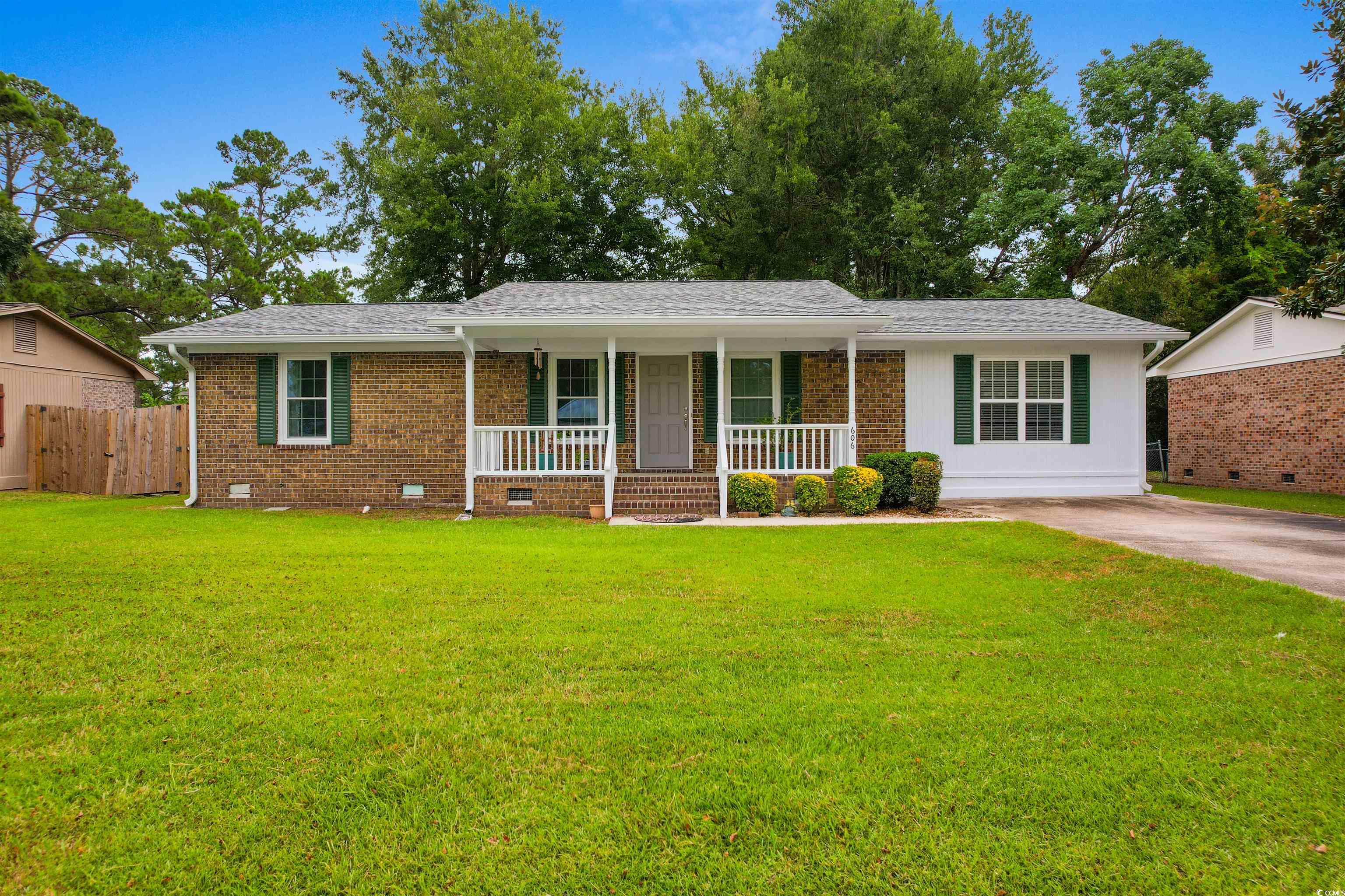 Single story home featuring a front yard and cover