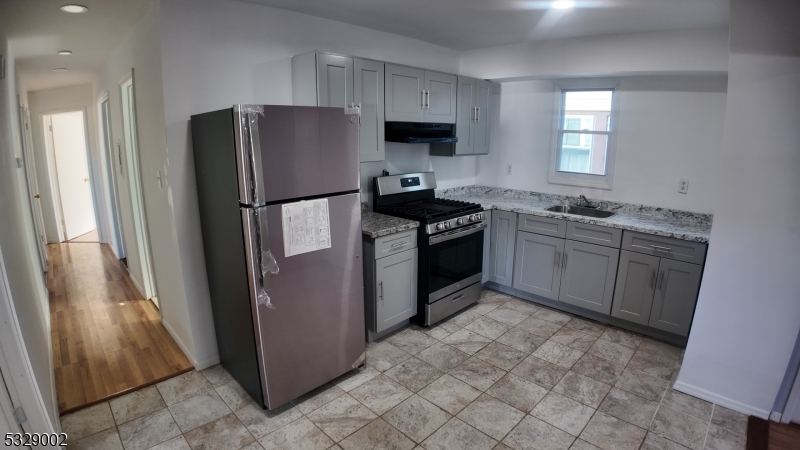 a kitchen with stainless steel appliances granite countertop a stove a refrigerator and a sink