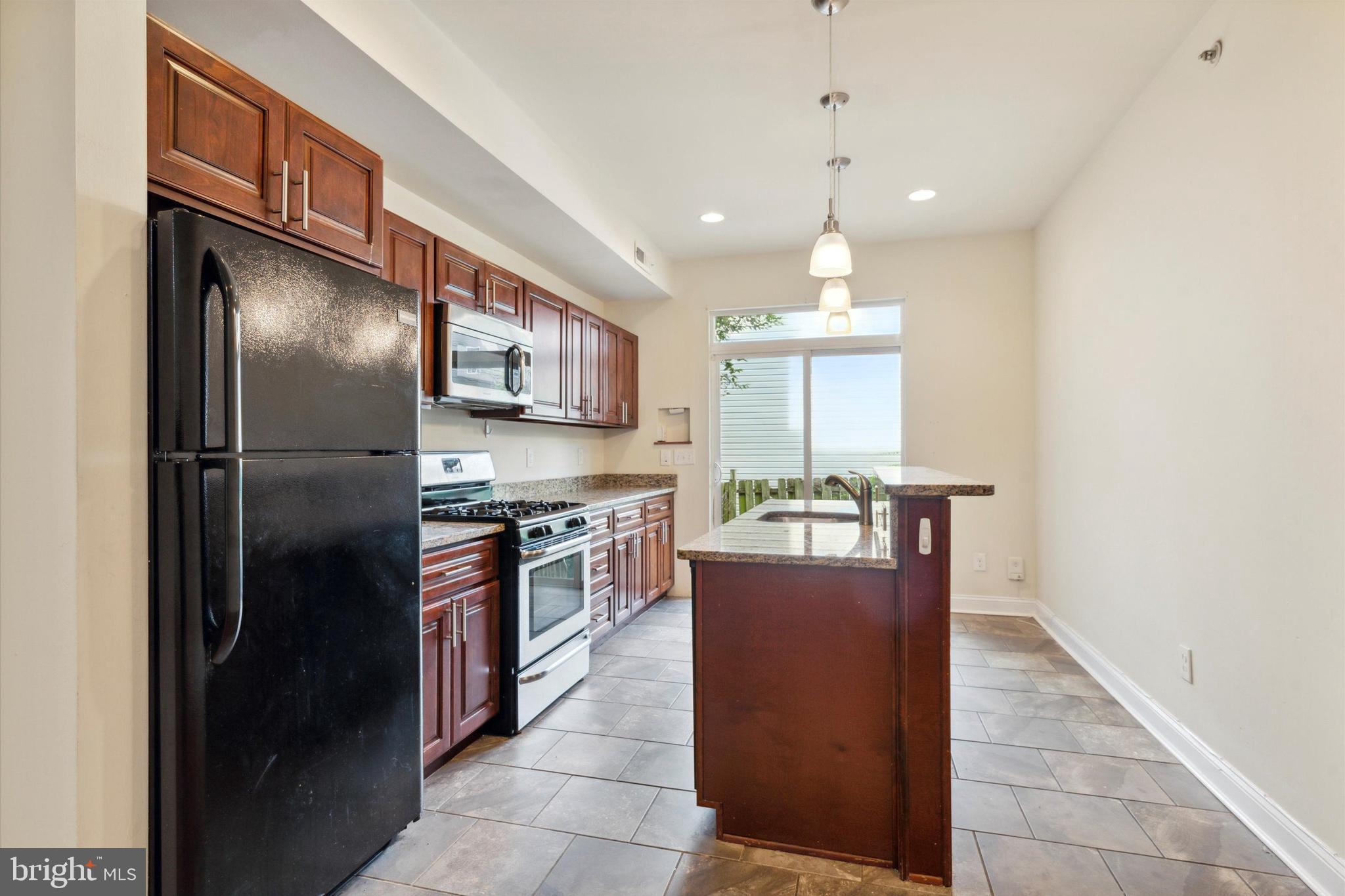 a kitchen with stainless steel appliances granite countertop a refrigerator a stove and a sink