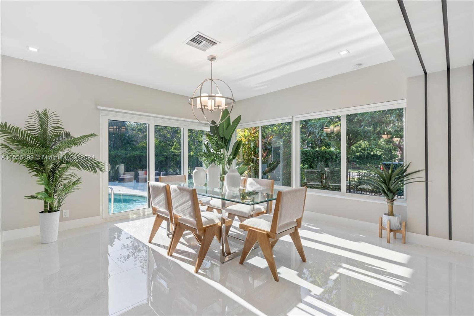 a dining room with furniture wooden floor a chandelier and a rug