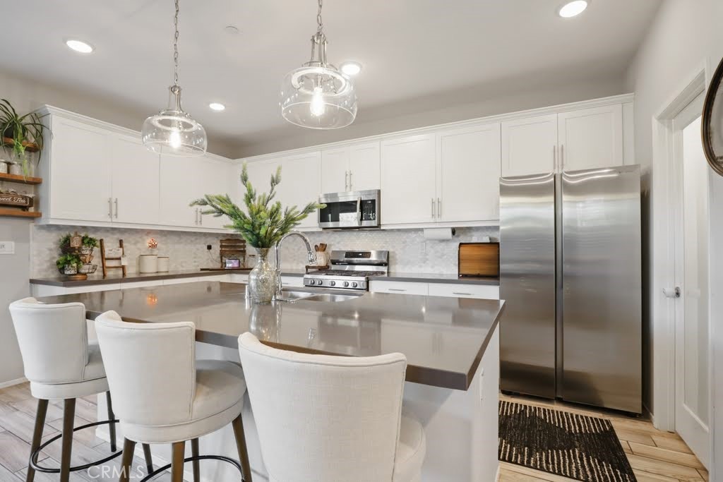 a kitchen with stainless steel appliances granite countertop a sink a stove and a refrigerator