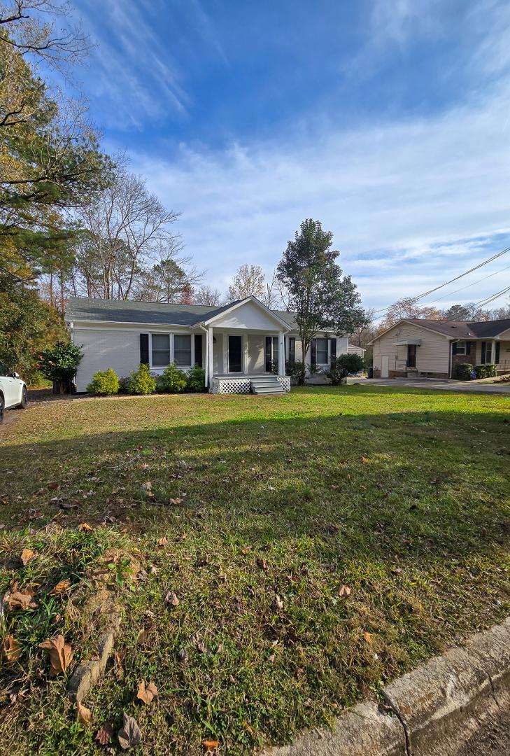 a view of a house with a big yard and large trees