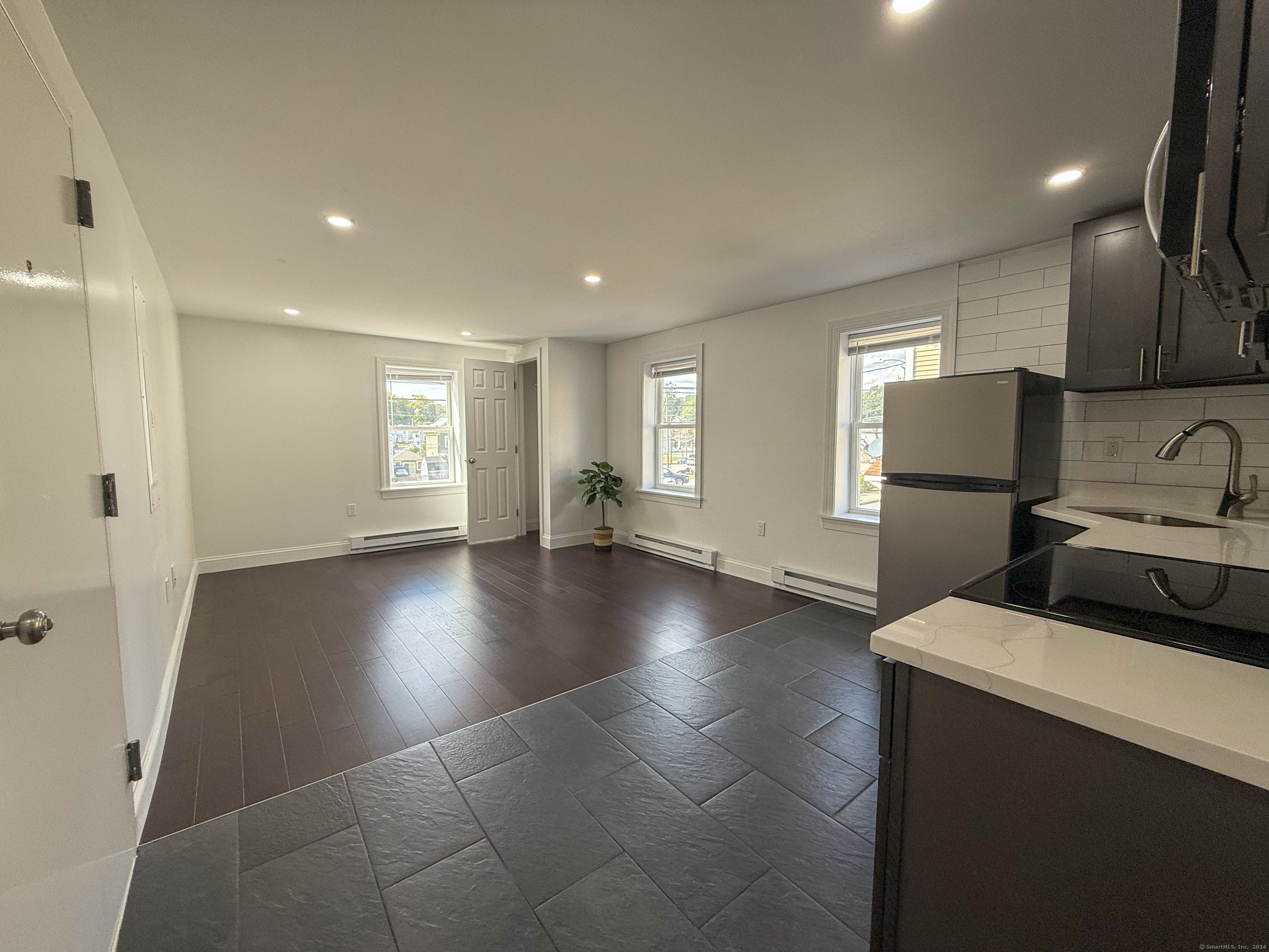 a view of empty room with kitchen view and window