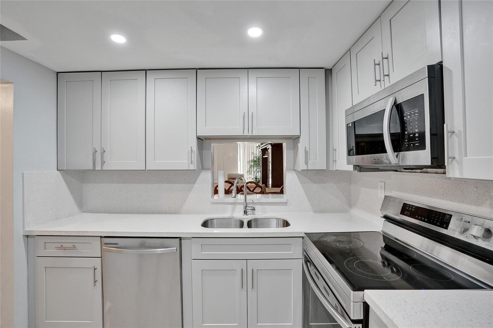 a kitchen with stainless steel appliances a sink stove and microwave