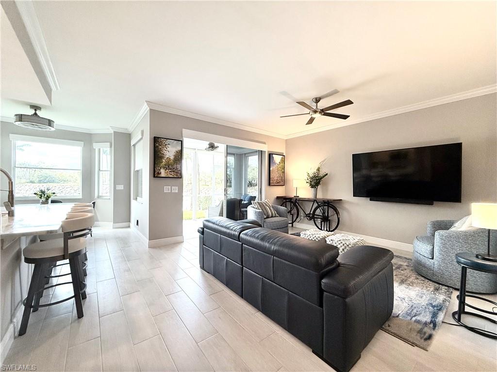 a living room with furniture a ceiling fan and a flat screen tv