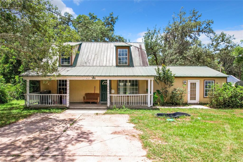 a front view of house with yard and trees around