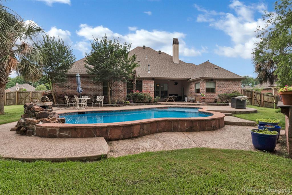 a front view of a house with swimming pool yard and patio