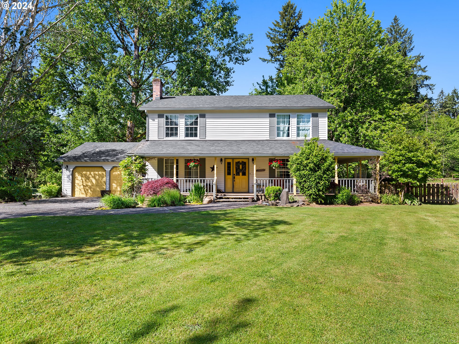 a front view of a house with a yard and trees