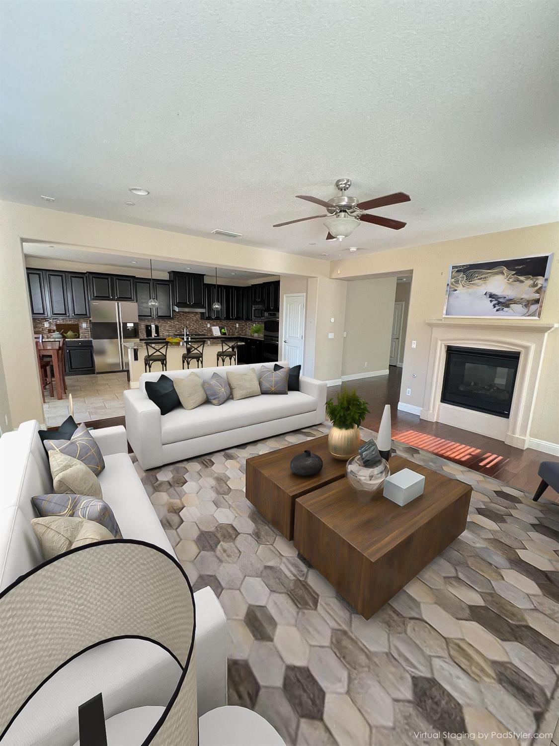 a living room with furniture a fireplace and a ceiling fan