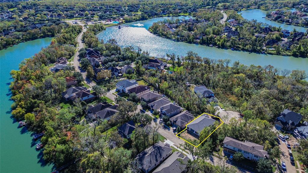 an aerial view of a house with a yard and lake view in back