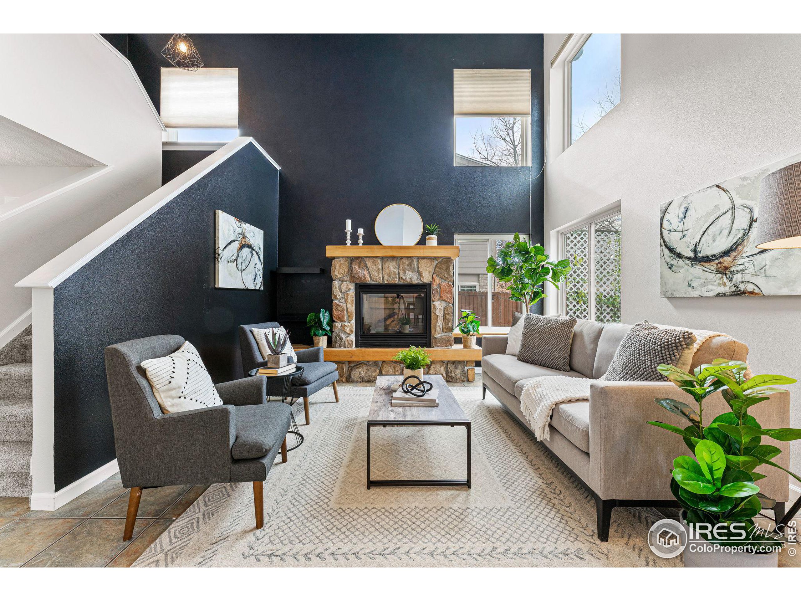 a living room with furniture a fireplace and a wall painting