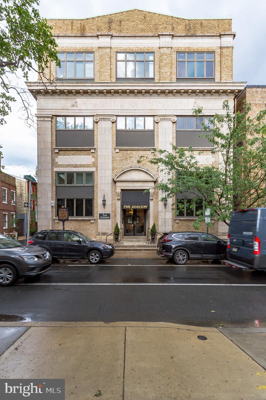 a view of a building and car parked on the road