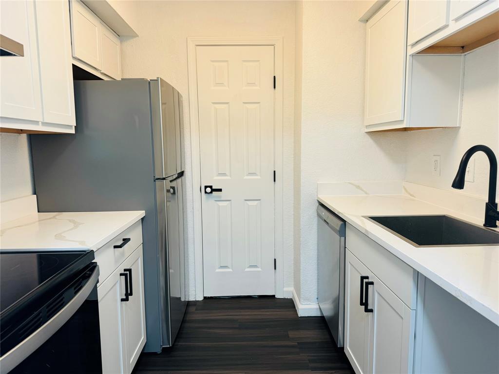 a kitchen with a sink a refrigerator and cabinets